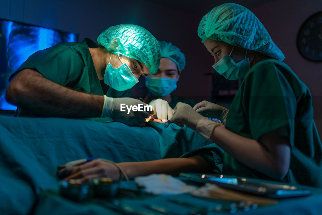 Doctors are using tools to perform patient procedures in the operating room. 