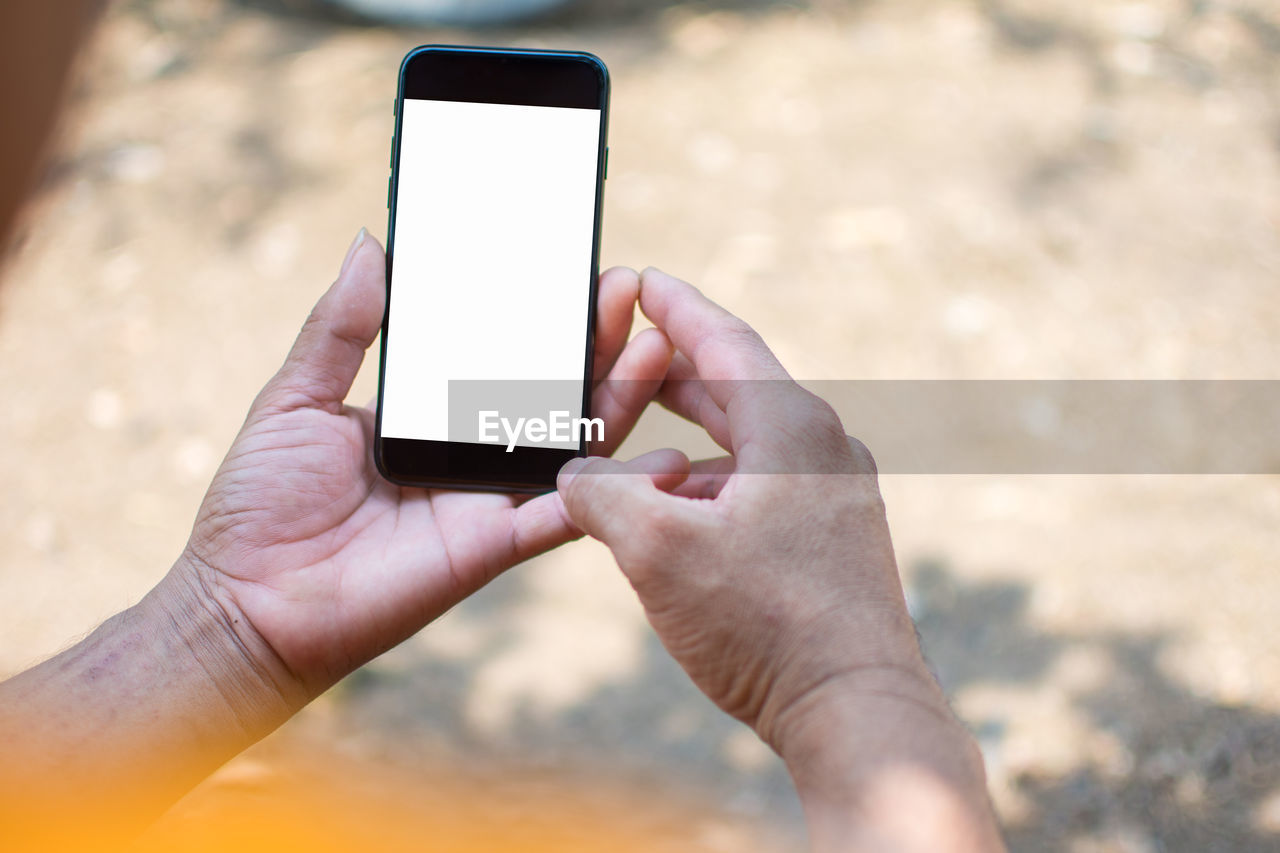 Close-up of cropped hands holding smart phone