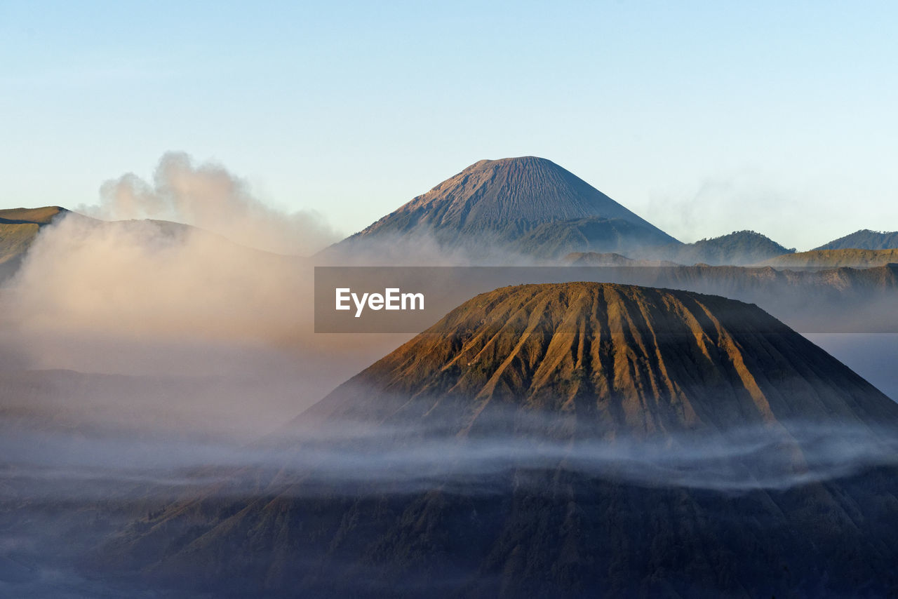 View on a mountain chain surrounded by clouds and fog, morning light, indonesia, java, mt. bromo