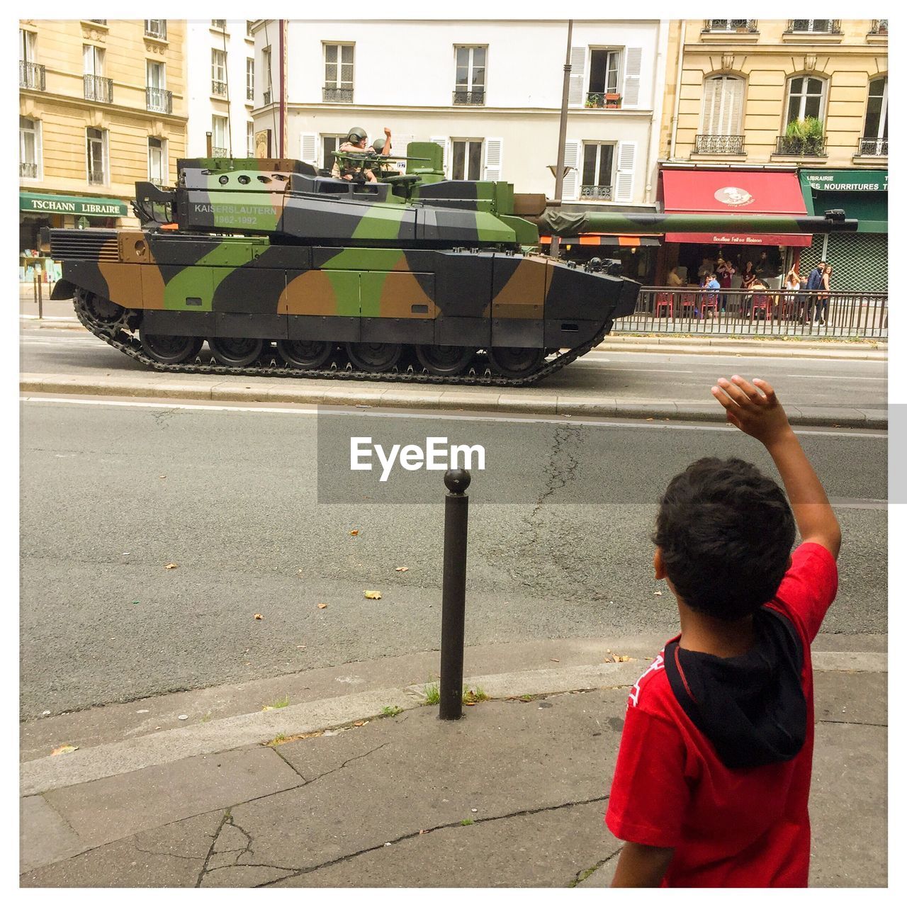 BOY PLAYING ON STREET AGAINST CARS