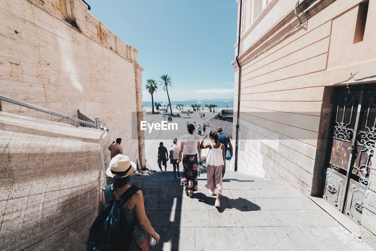 People walking in alley during sunny day