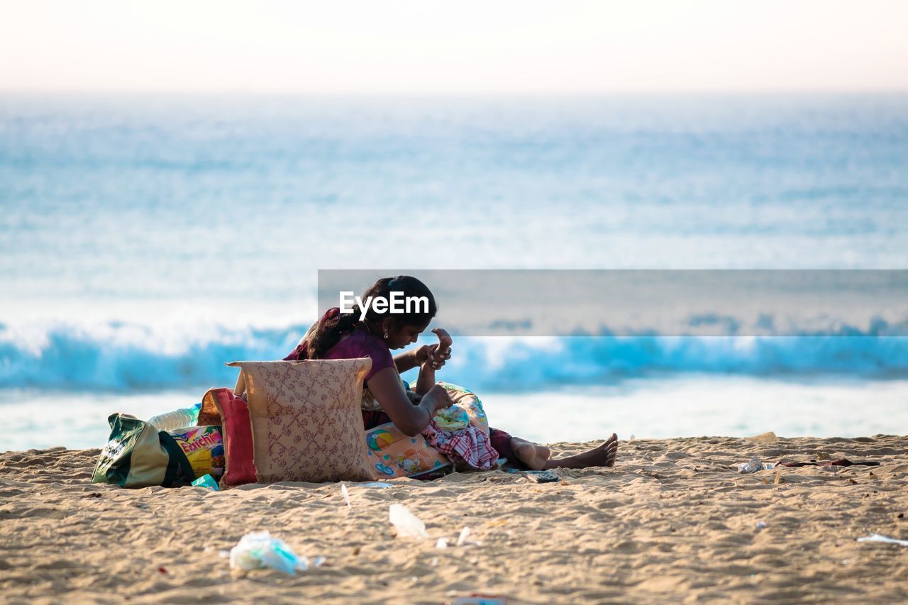 Mother with child on shore at beach