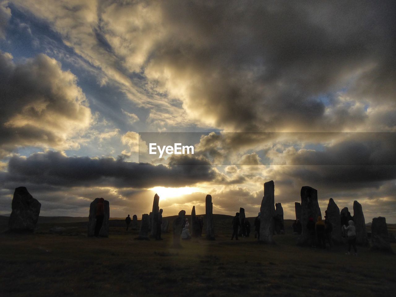 Calanais standing stones against sky cloudy during sunset