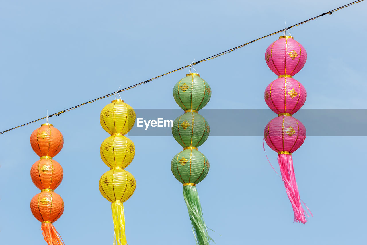 LOW ANGLE VIEW OF LANTERNS AGAINST CLEAR SKY
