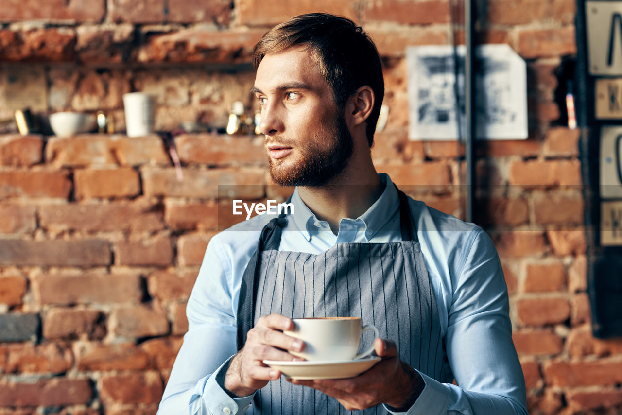 YOUNG MAN DRINKING COFFEE CUP