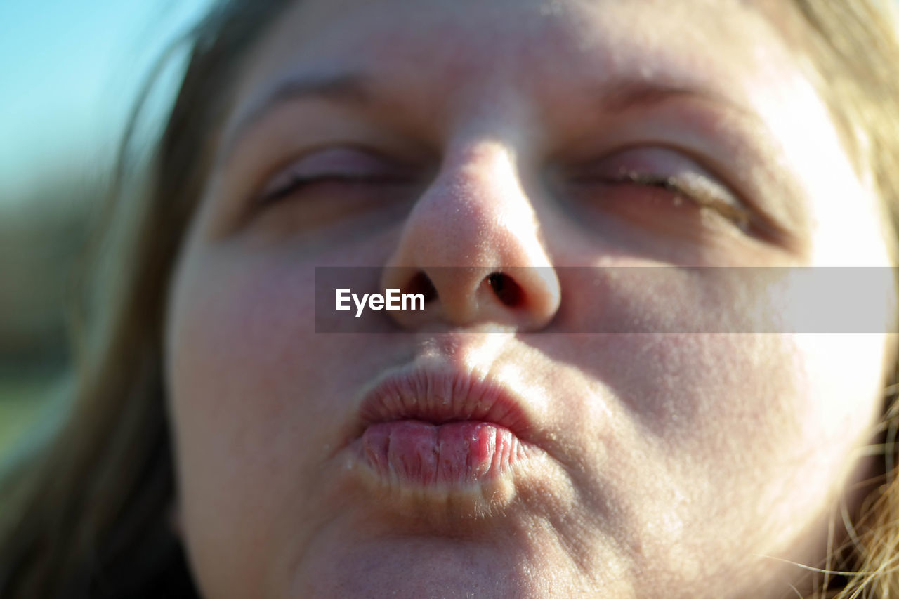 Close-up of woman puckering lips outdoors