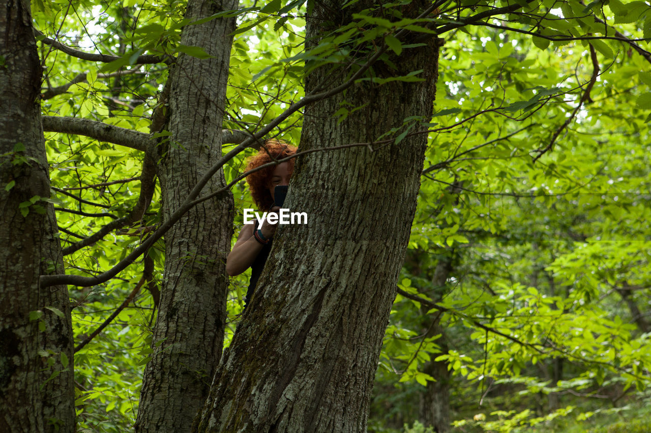 Woman using mobile phone in forest