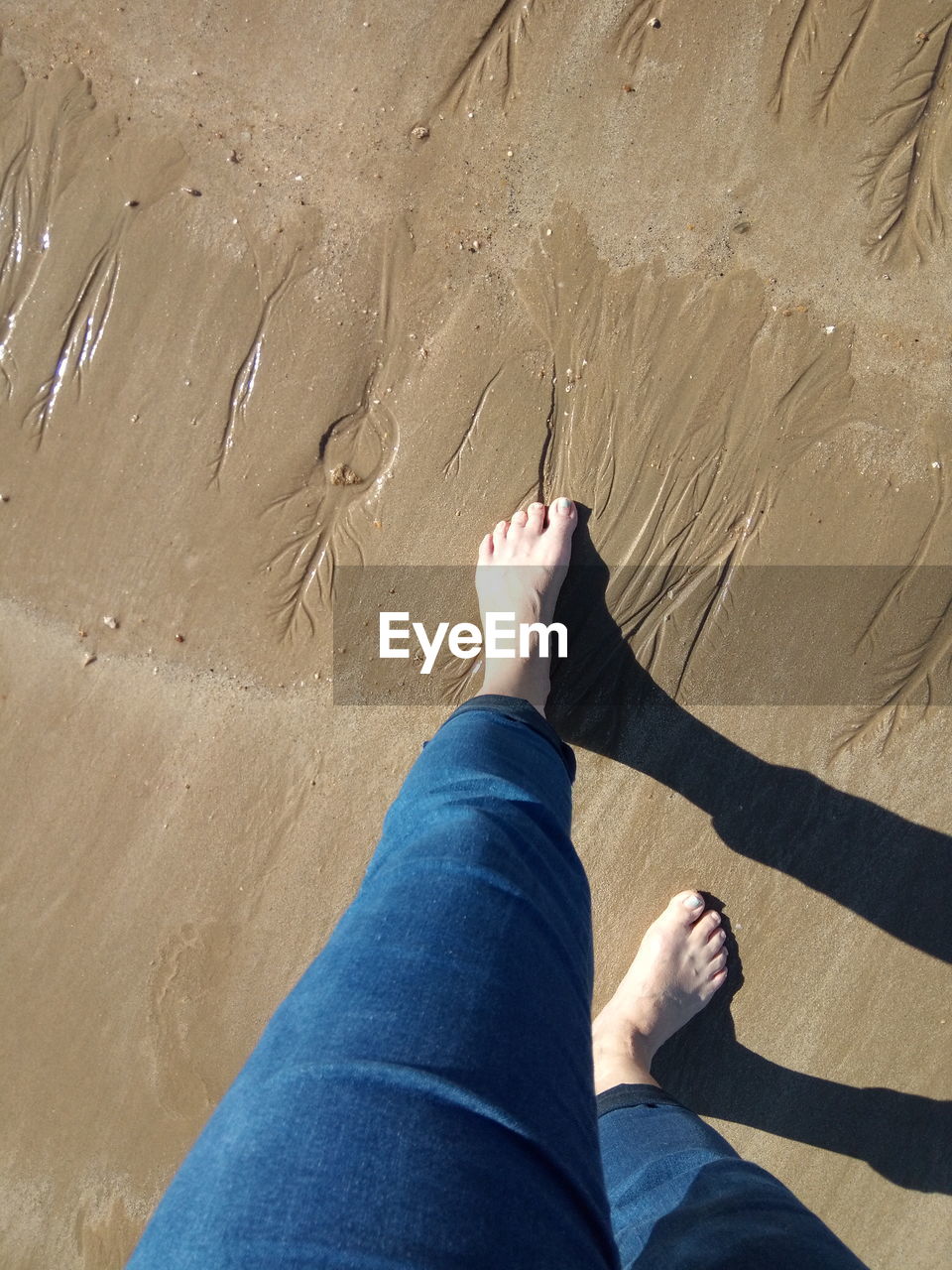 LOW SECTION OF PERSON ON SAND