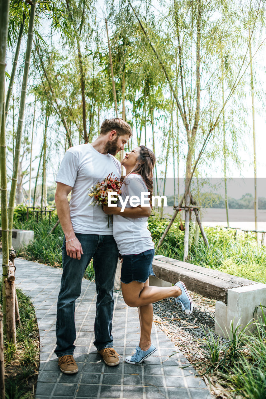 Boyfriend standing with girlfriend in forest