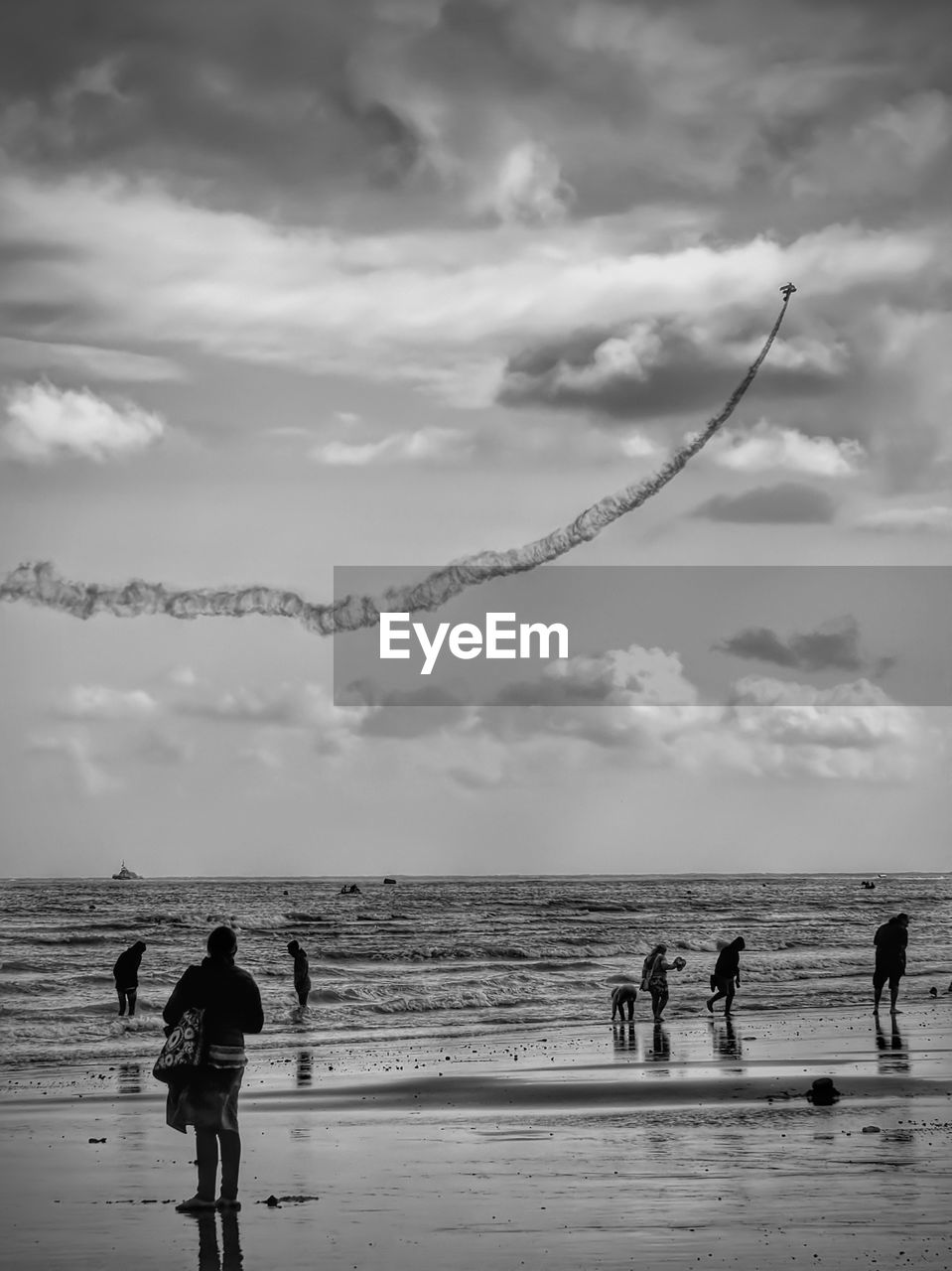 MEN ON BEACH AGAINST SKY