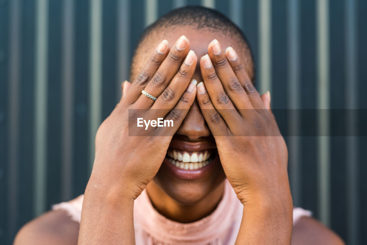 Close-up of laughing woman covering face