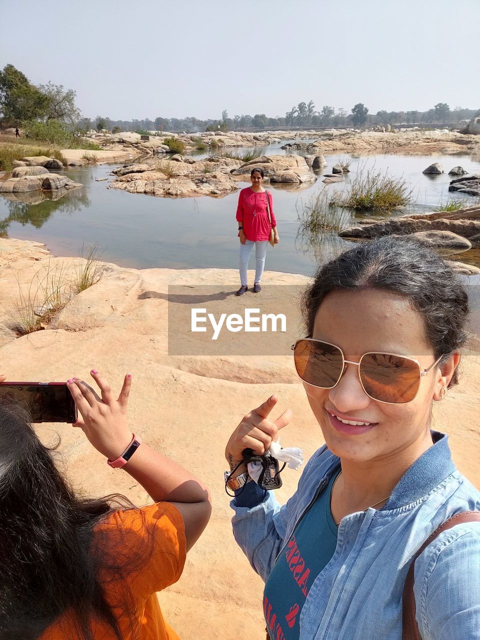 PORTRAIT OF WOMAN WITH SUNGLASSES ON BEACH