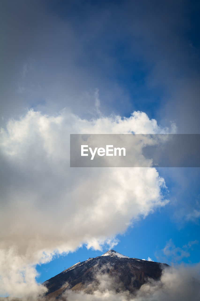 LOW ANGLE VIEW OF CLOUDS OVER MOUNTAIN AGAINST SKY