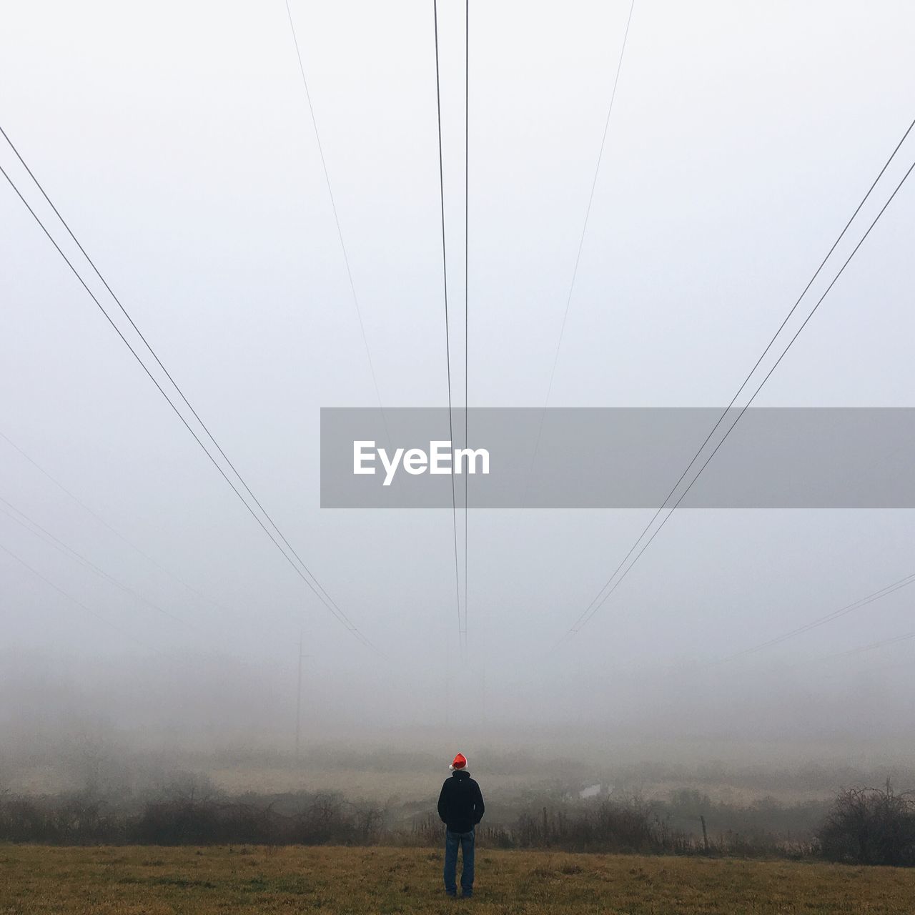 Man standing on field in foggy weather