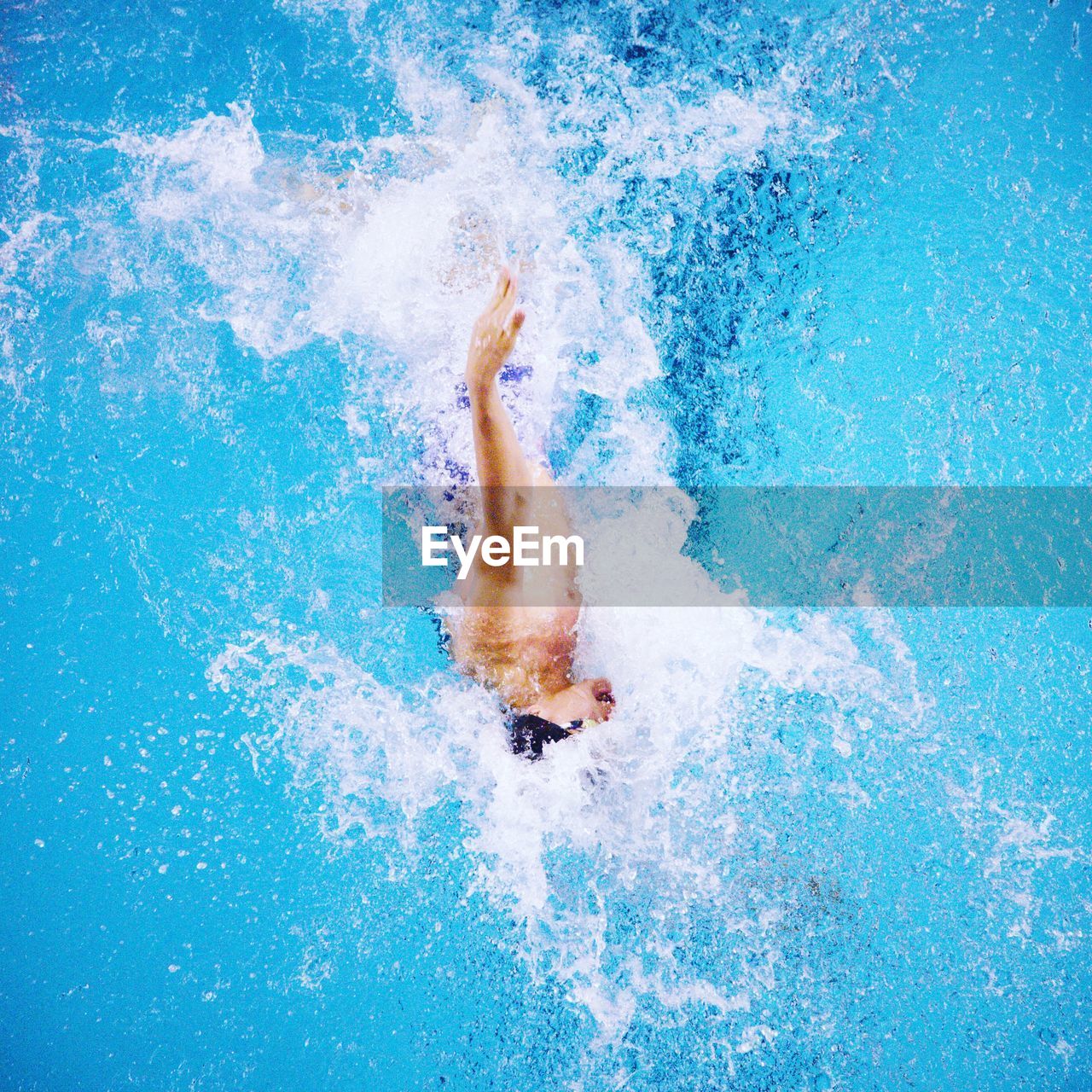 Man swimming backstroke in pool