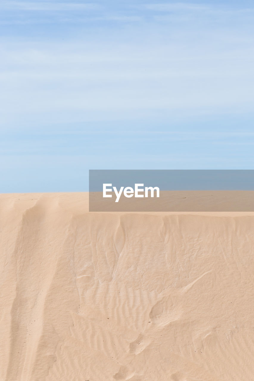 Sand dune in desert against sky