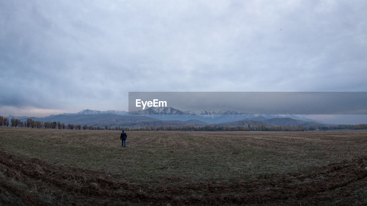 Scenic view of grassy field against cloudy sky