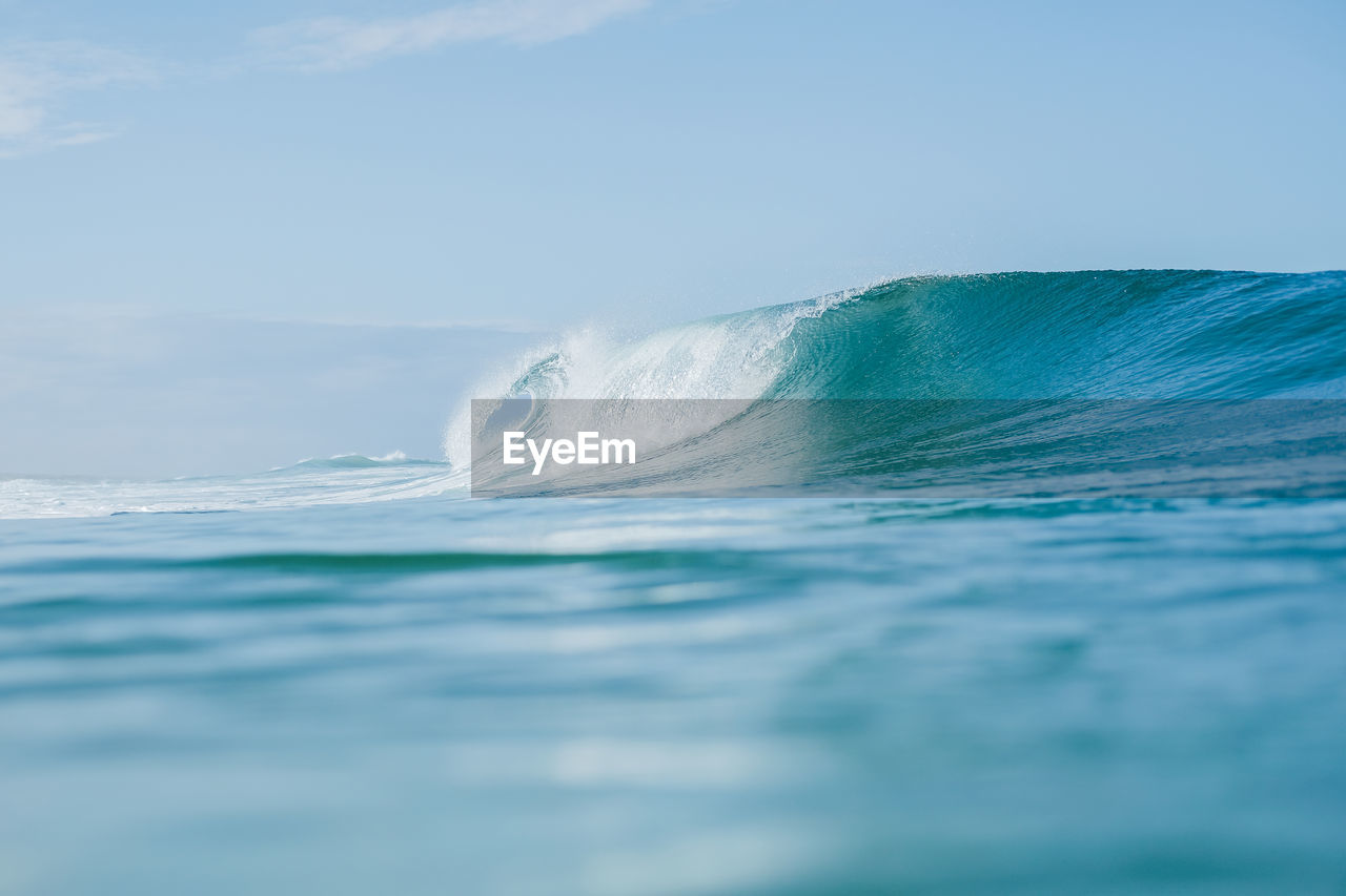 Scenic view of waves in sea against sky