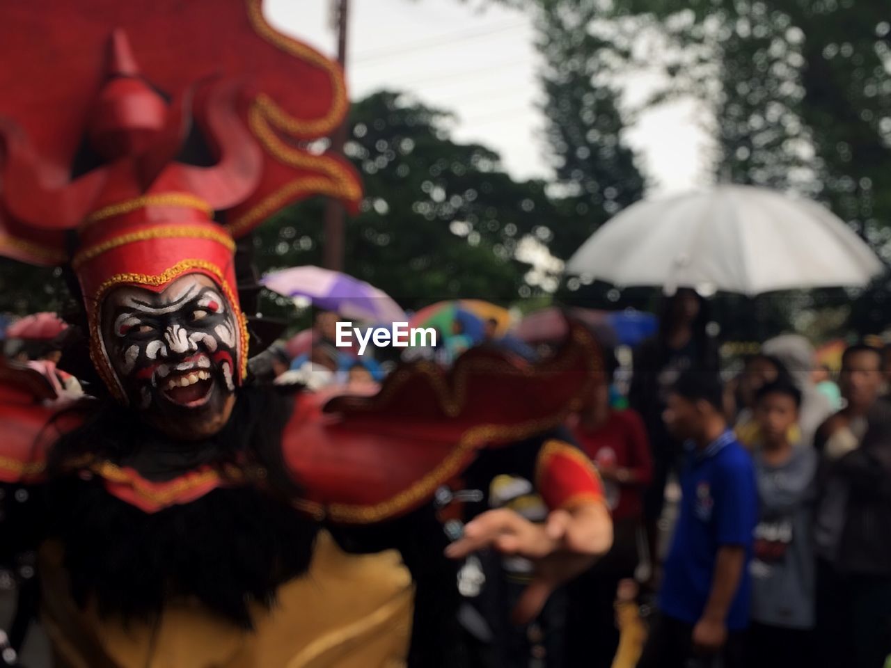 CLOSE-UP OF PEOPLE ON MULTI COLORED UMBRELLAS