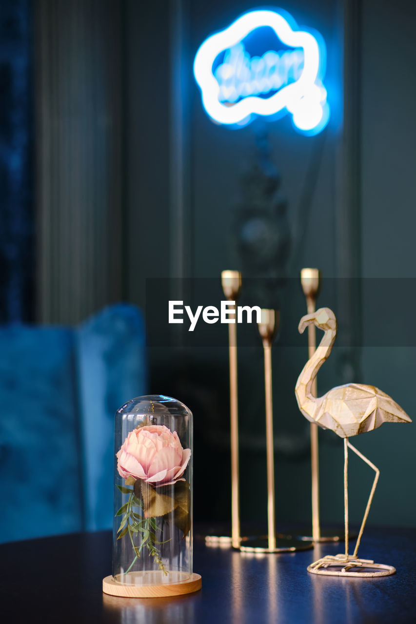 Stylish statuette of flamingo and rose in a glass jar
