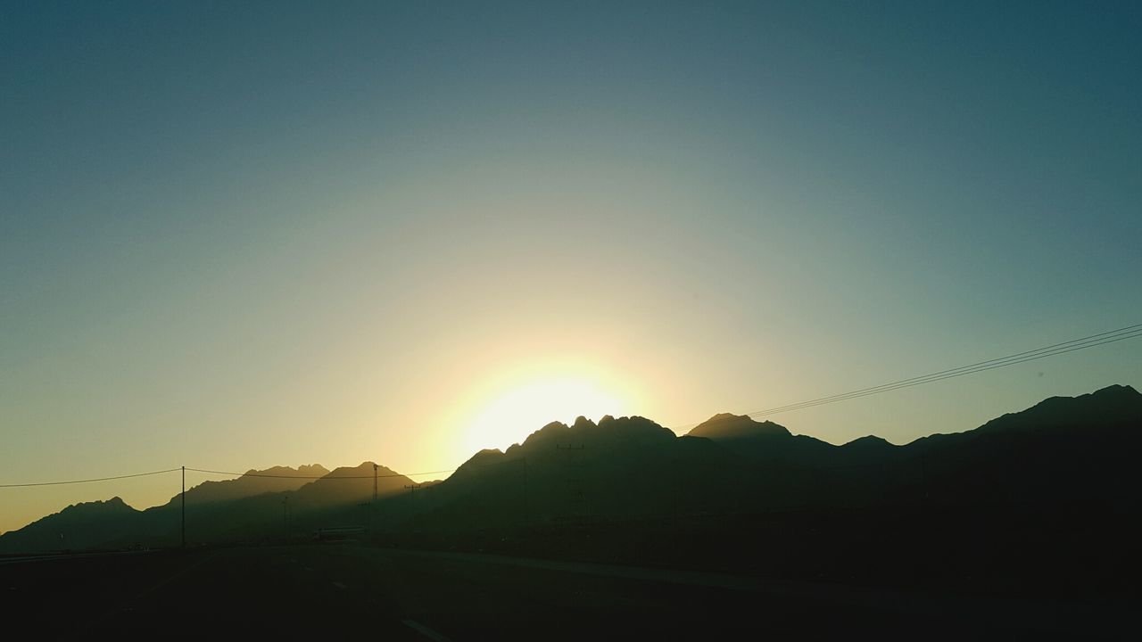 SCENIC VIEW OF SILHOUETTE MOUNTAIN AGAINST SKY AT SUNSET