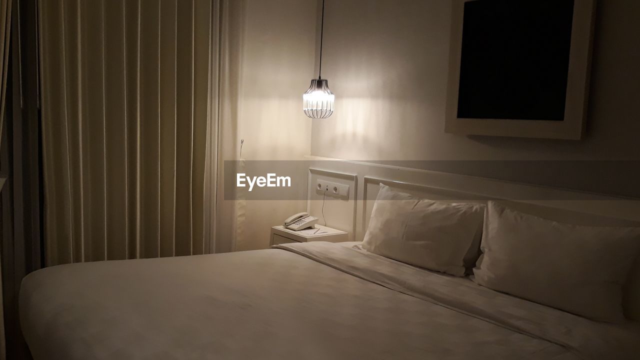 Illuminated electric lamp in bedroom at home