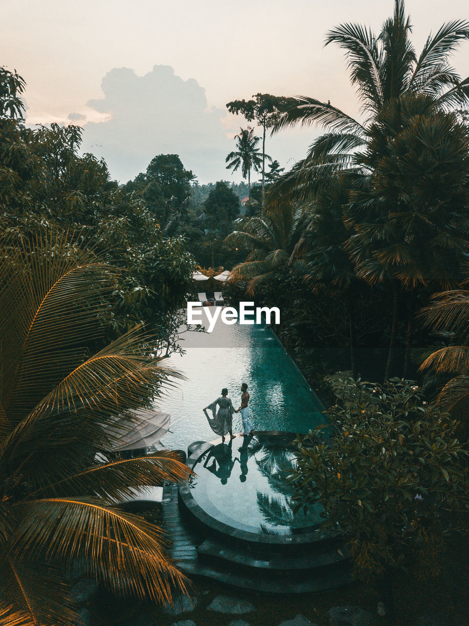 PEOPLE IN SWIMMING POOL AGAINST SKY