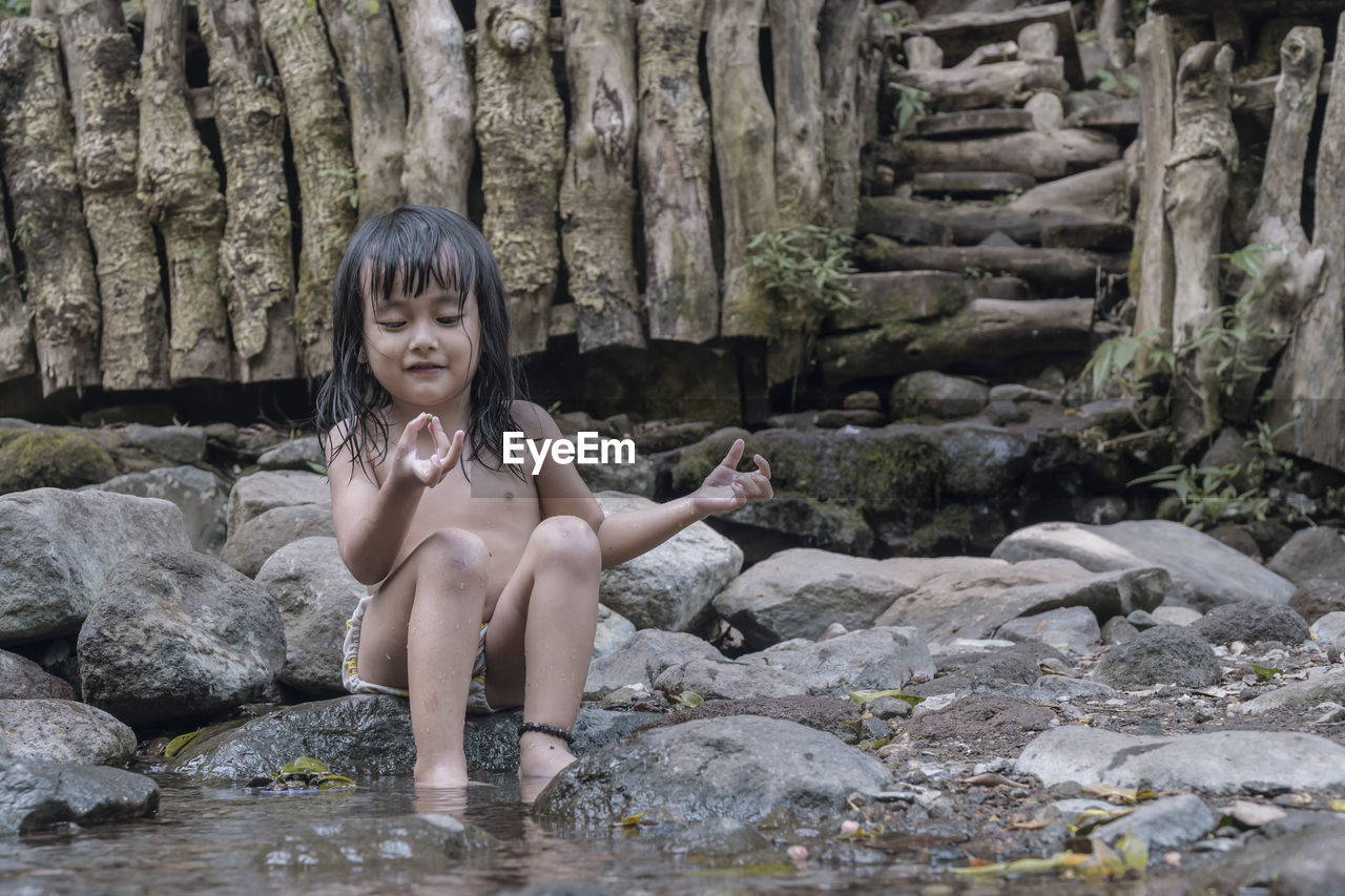 Portrait of boy sitting on rock