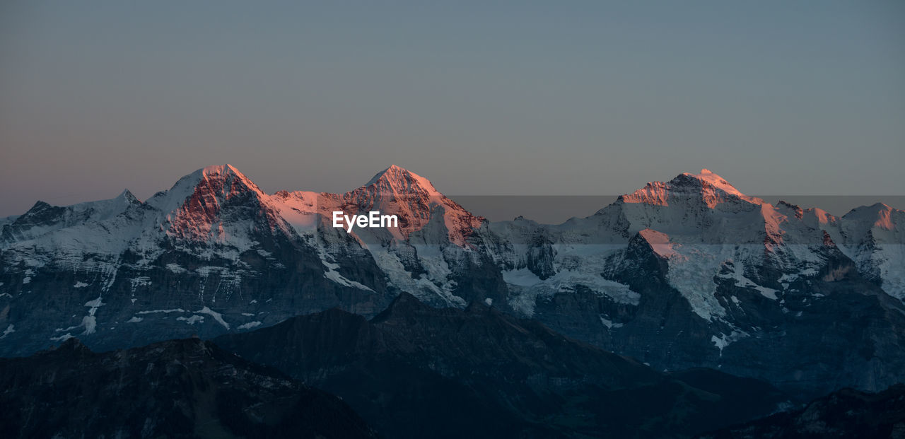 Scenic view of snowcapped mountain against sky during sunset