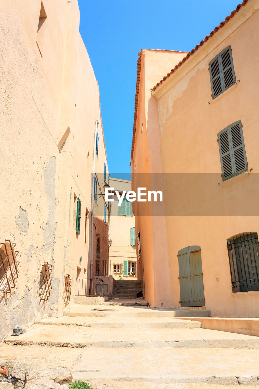 Street amidst buildings against blue sky