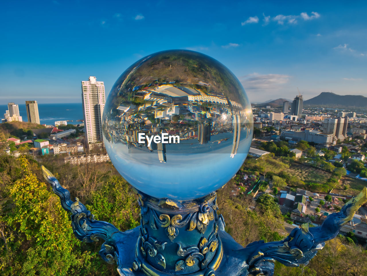 Photos of a king of nagas statue and big crystal ball view reflection of the sriracha city.