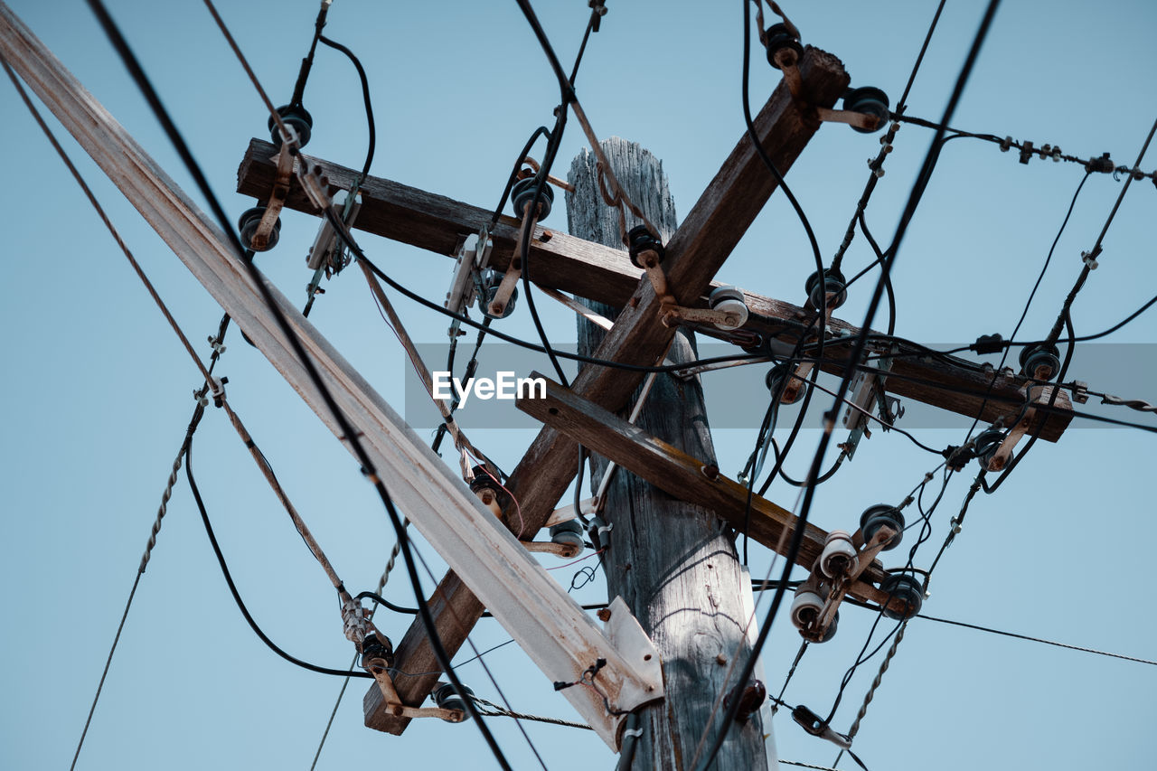 LOW ANGLE VIEW OF ELECTRICITY PYLON AGAINST CLEAR BLUE SKY