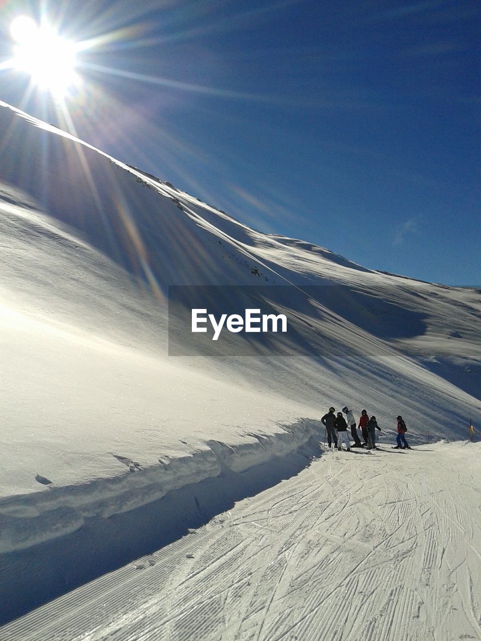 People on snowcapped mountains during sunny day