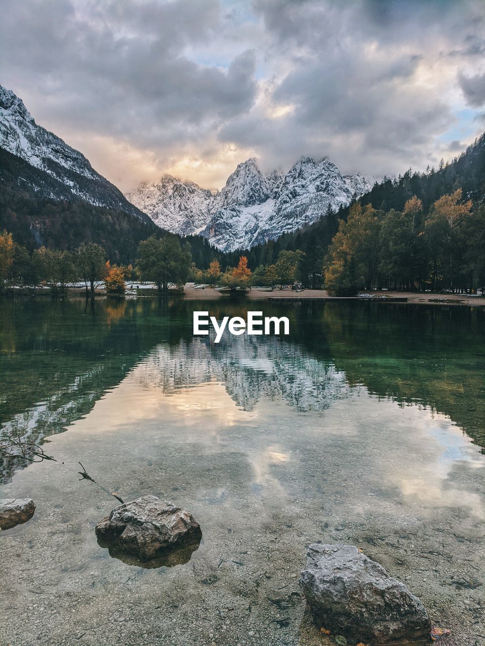 Scenic view of lake by snowcapped mountains against sky