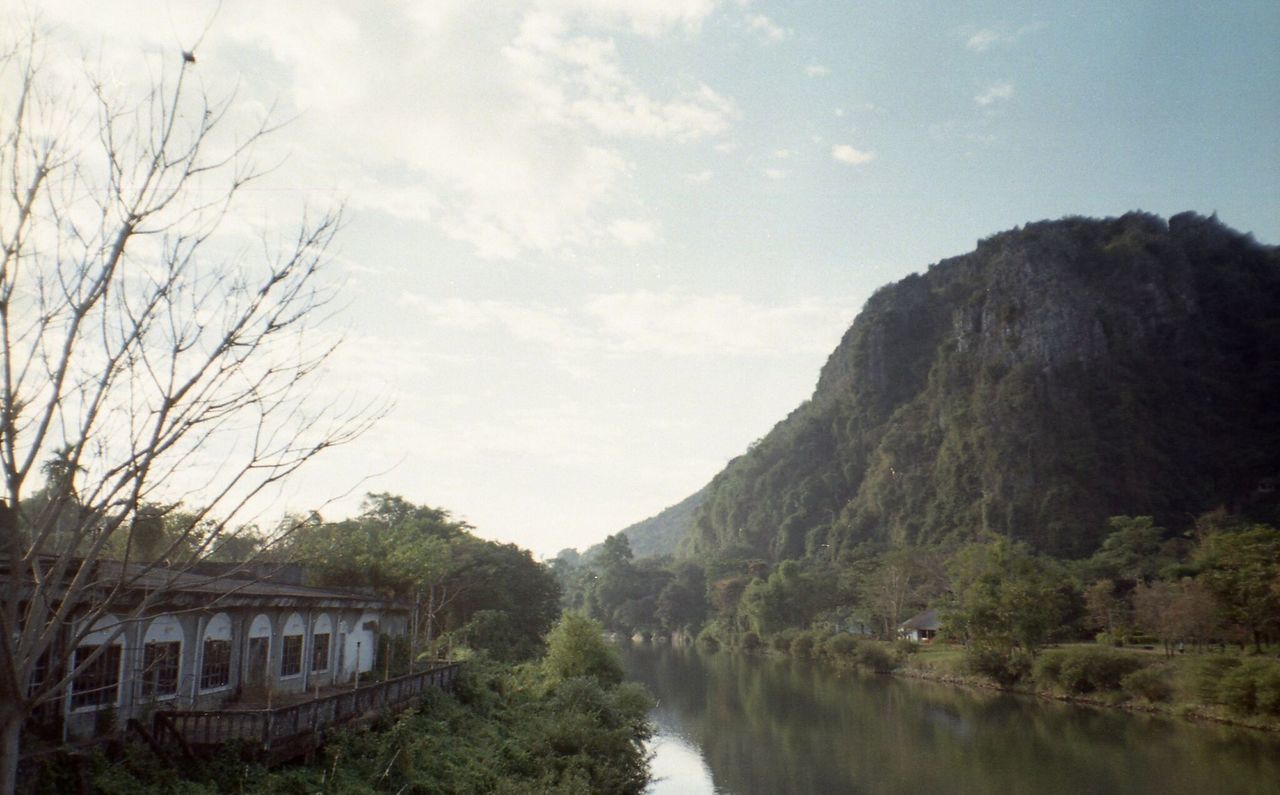 RIVER FLOWING AMIDST TREES AGAINST SKY