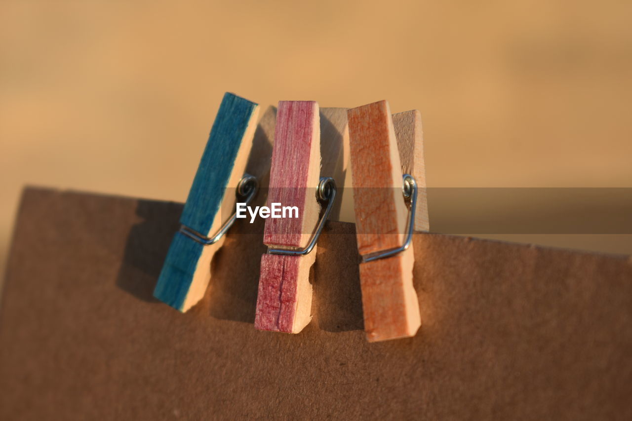 HIGH ANGLE VIEW OF MULTI COLORED CLOTHESPINS ON TABLE