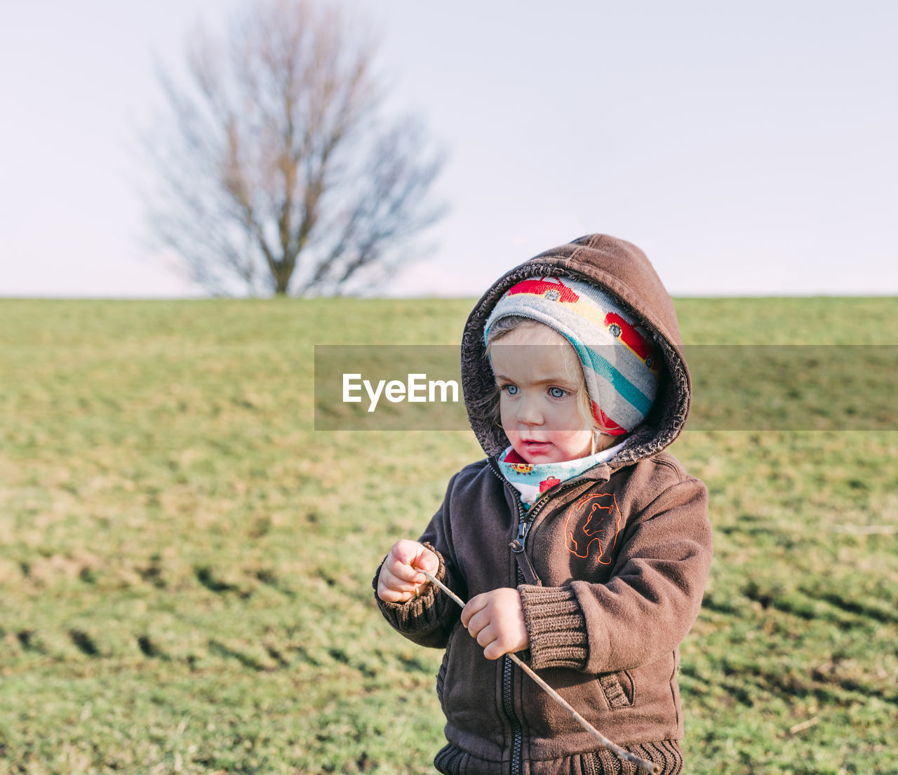 Cute girl standing on field during winter