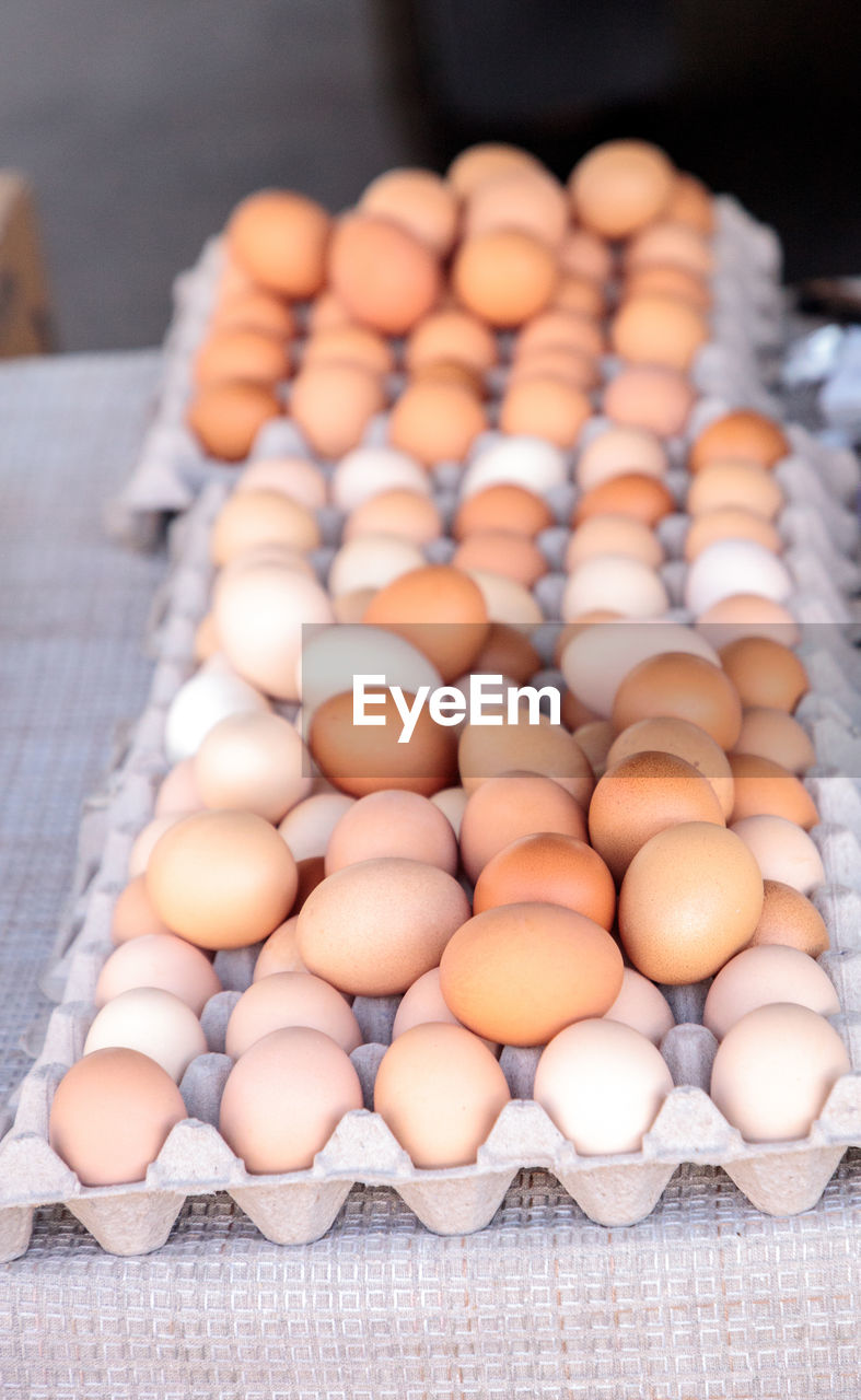 Egg crates of brown and white eggs at a local farmers market from organic chickens.