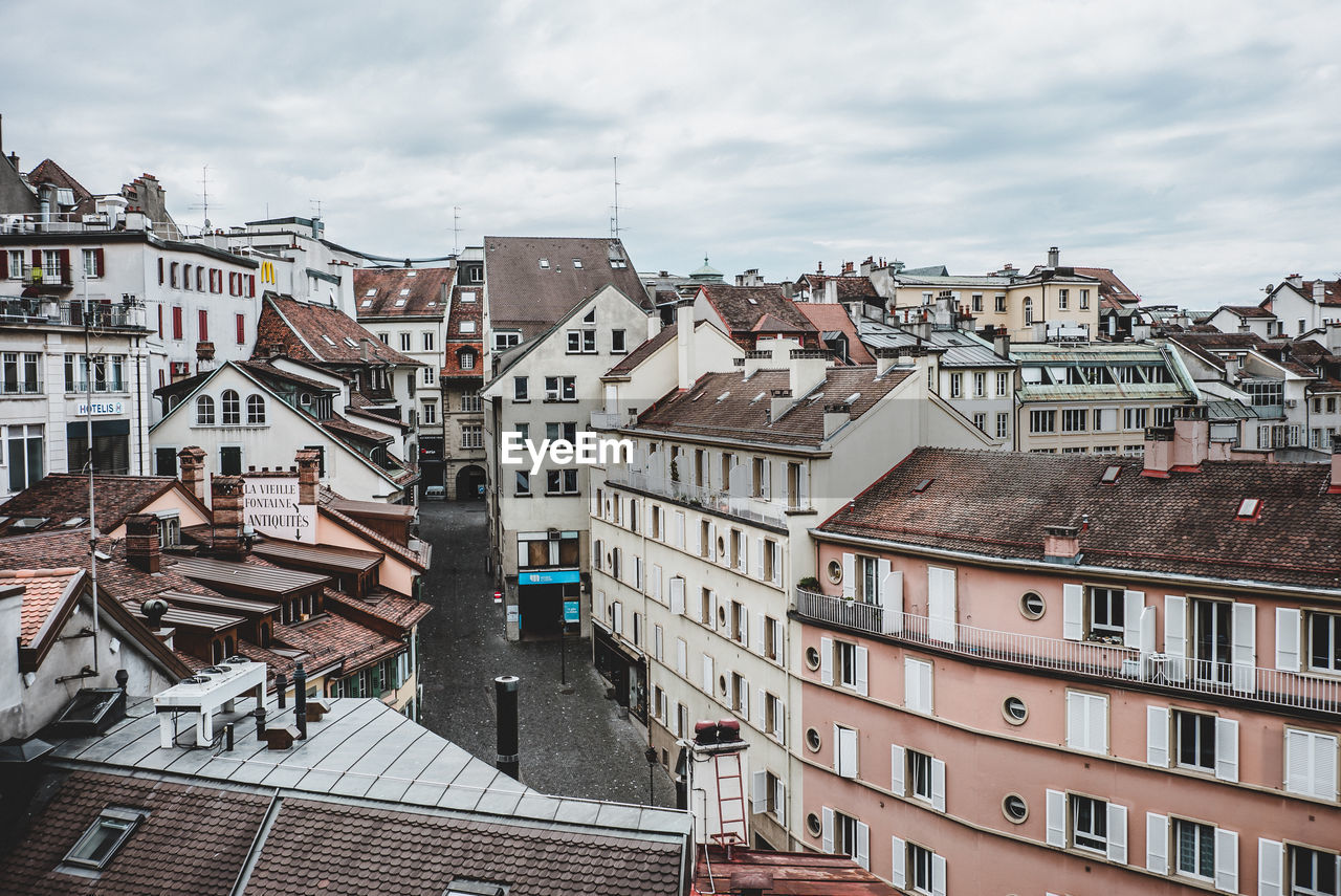 Houses by river against sky