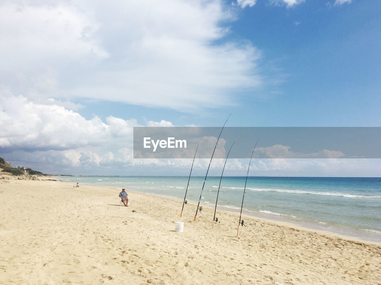 Fishing rods on shore against sky at beach