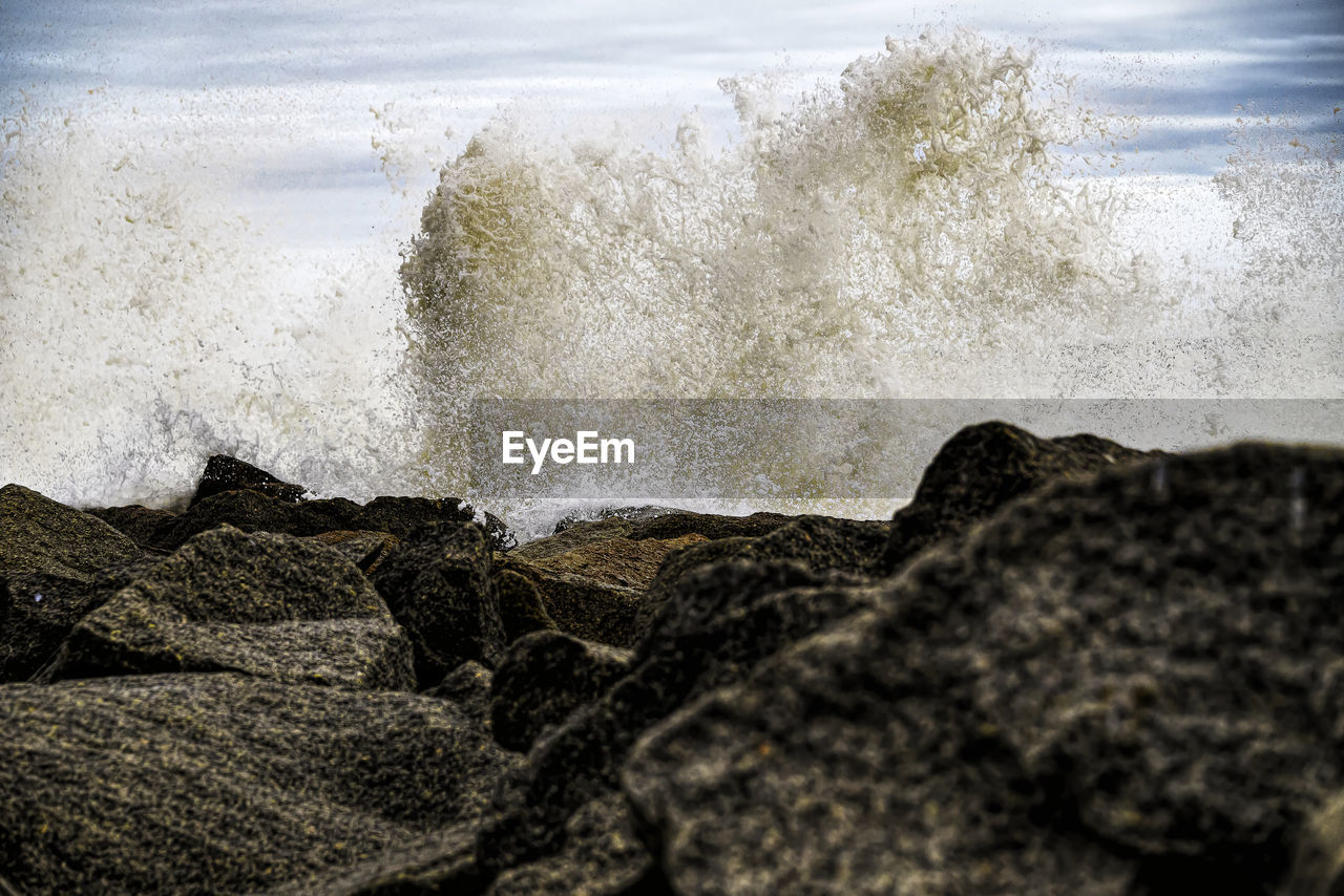 WAVES SPLASHING ON ROCKS AT BEACH