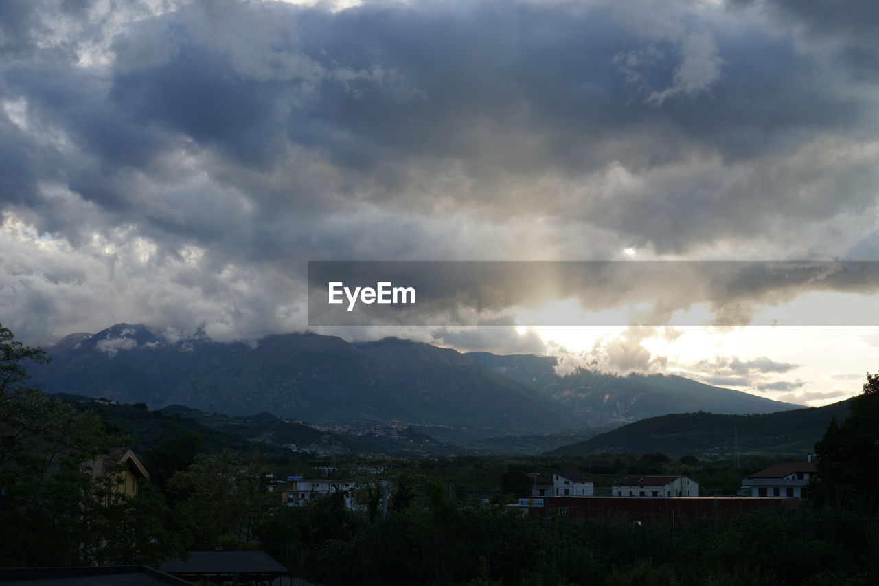 SCENIC VIEW OF MOUNTAINS AGAINST CLOUDY SKY