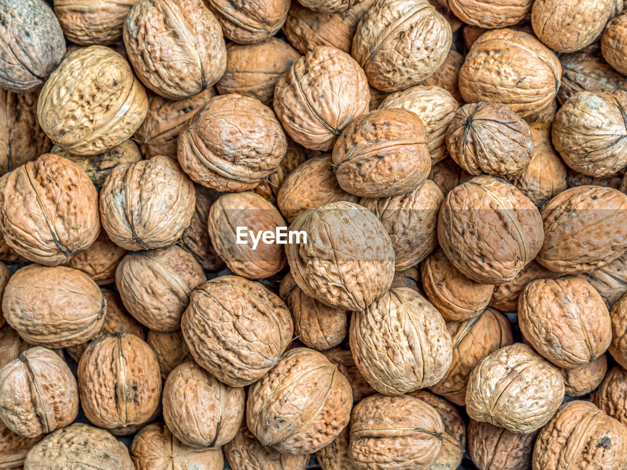 Pile of walnuts in shell shot from above