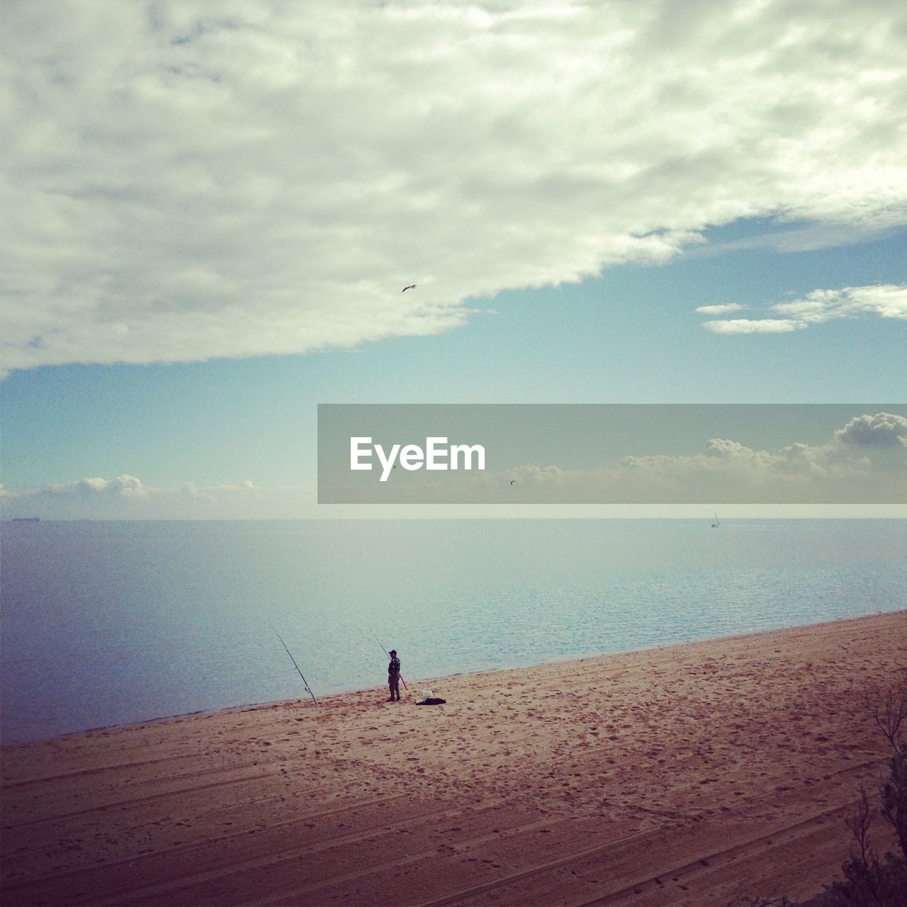 MAN ON BEACH AGAINST SKY