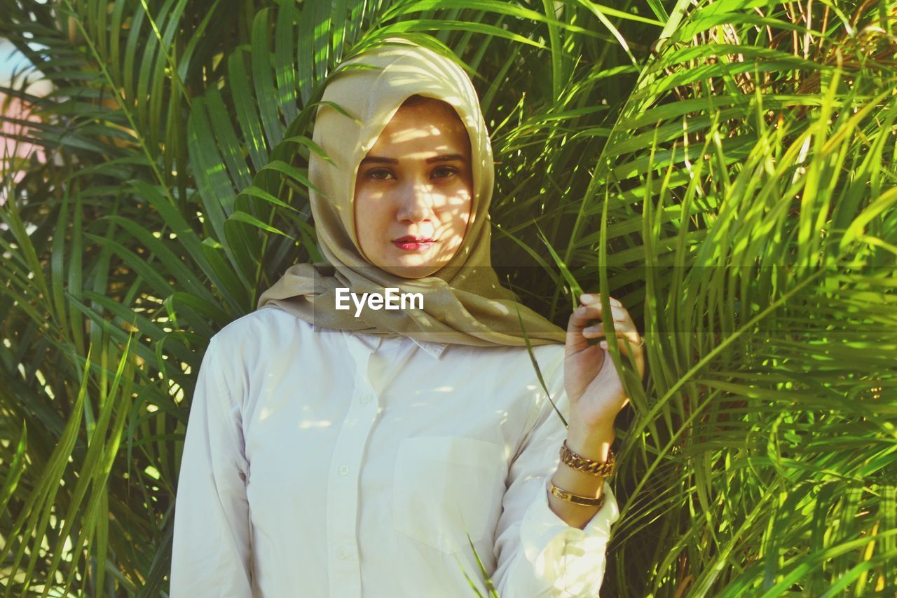 PORTRAIT OF A YOUNG WOMAN WEARING SUNGLASSES OUTDOORS