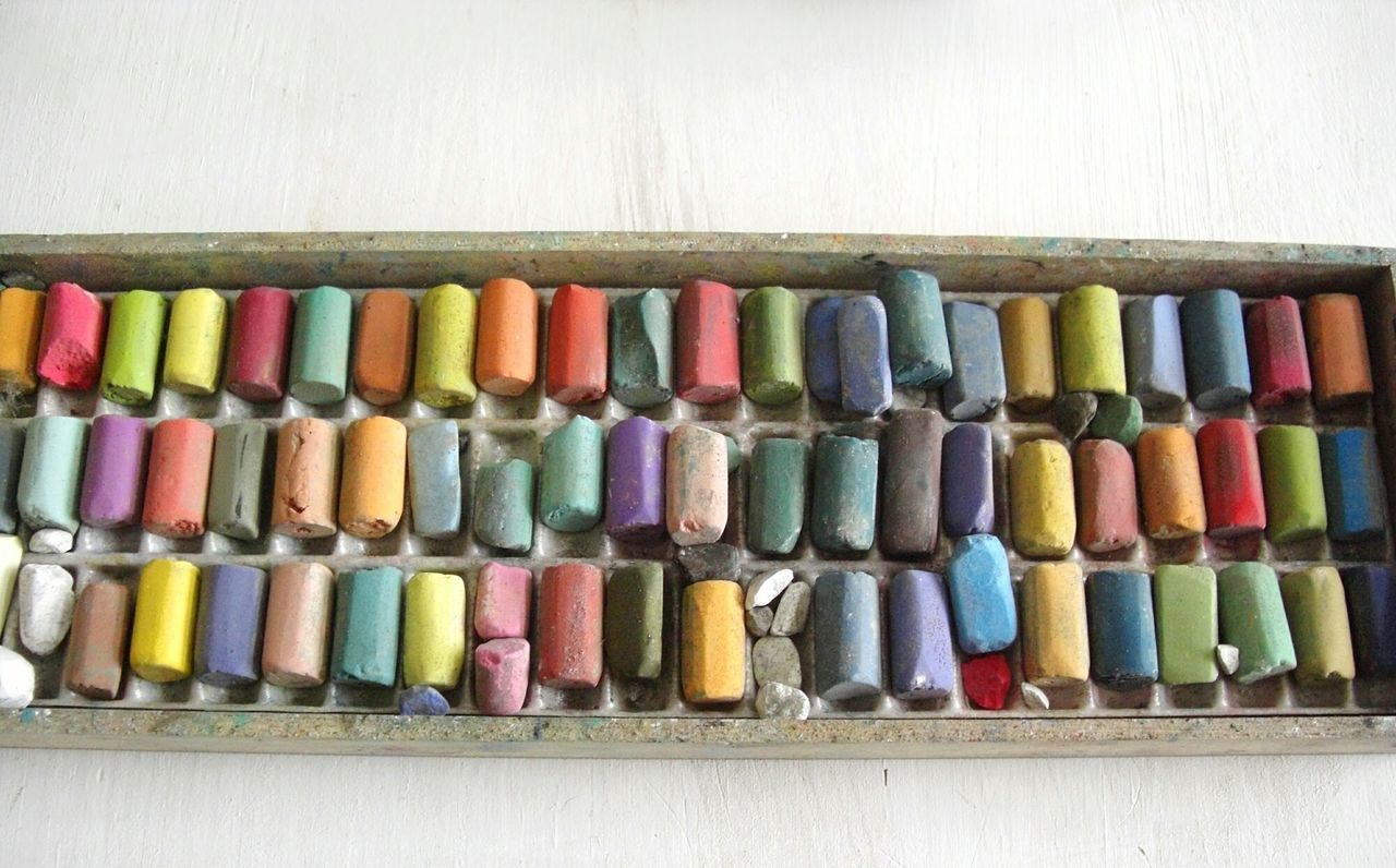 CLOSE-UP OF MULTI COLORED BOTTLES IN SHELF