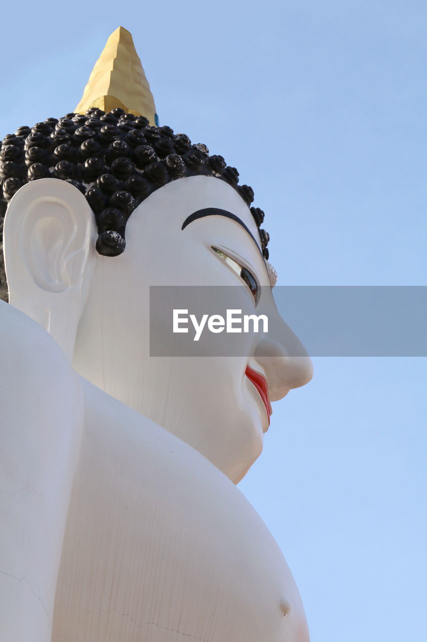 Low angle view of buddha statue against clear sky