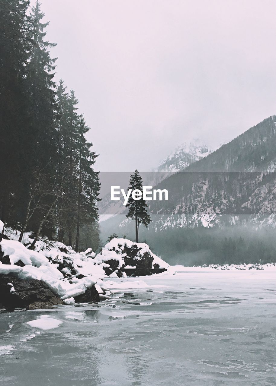 SCENIC VIEW OF FROZEN LAKE AGAINST SKY DURING WINTER