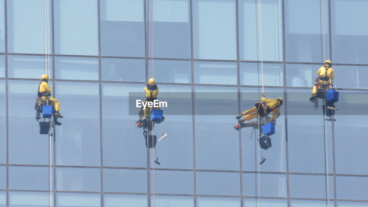 Low angle view of window washers cleaning office building