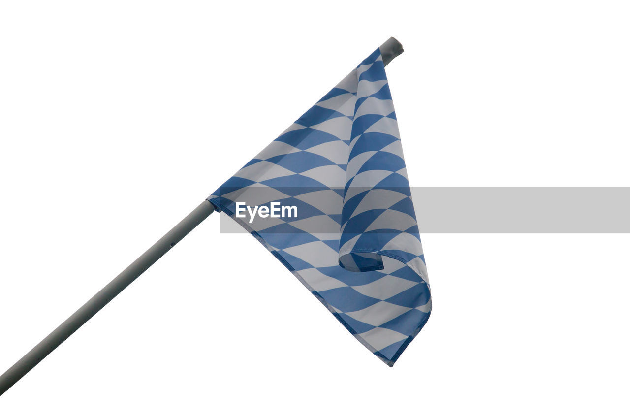 Low angle view of blue and white checked flag against clear sky